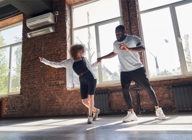 Two adults learning a dance.