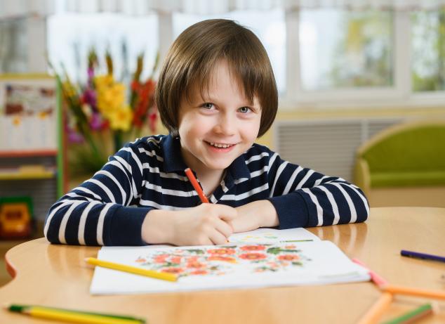 Boy drawing in notebook.